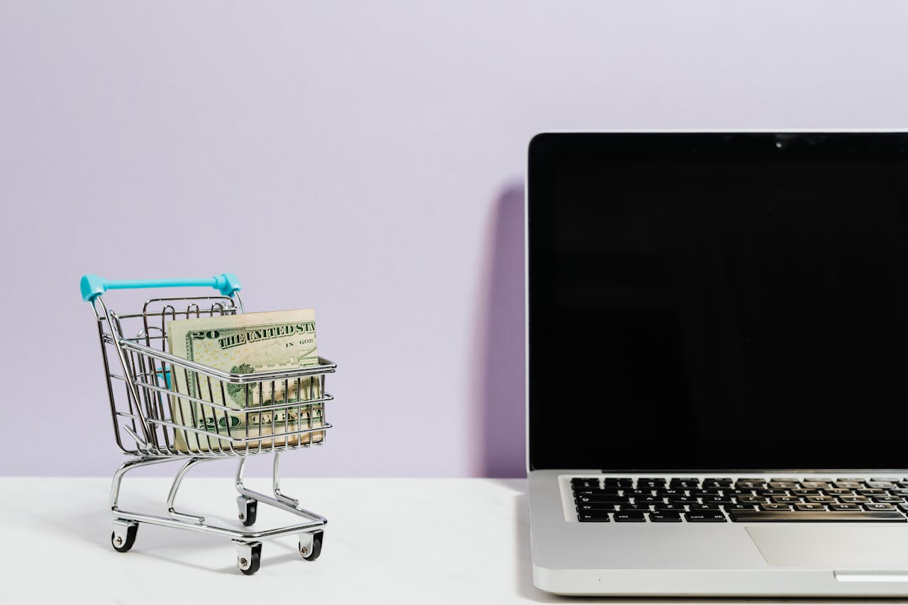 Shopping Cart Next to a Laptop